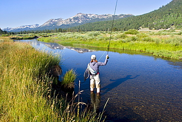 Young woman fly fishing the West Fork of the Carson River in Hope Valley. Lake Tahoe, California.