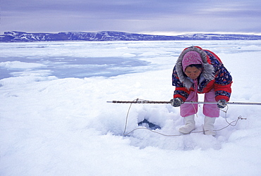 During a camping trip, Komangapik Muckpa hunts for seal in Arctic Bay. Camping is a favorite late spring activity. As soon as school is over in May, everyone heads out of town with their families to camp.