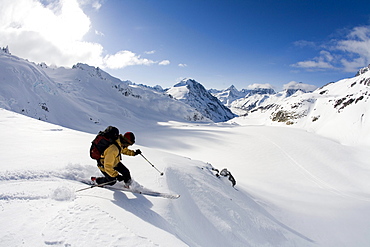 Man telemark skis down hill in Canada backcountry near Alaska Canada border