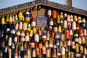 Colorful bouys on the Towsend Lobster Company building on the pier at sunset in Provincetown, Massachusetts.