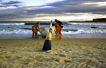 A group of people preparing a surf boat in Sydney, Australia.