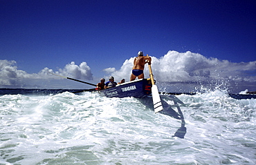 A group of people on a surf boat during a surf carnival in Sydney, Australia.