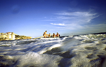 A group of people on a surf boat during a surf carnival in Sydney, Australia.