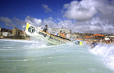 A group of people on a surf boat during a surf carnival in Sydney, Australia.