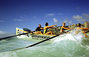 A group of people on a surf boat during a surf carnival in Sydney, Australia.