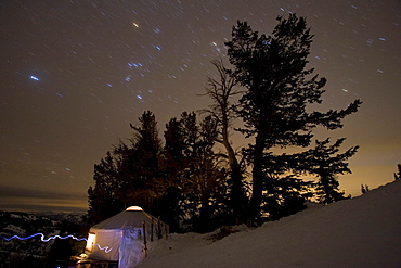 Lit up yurt at night with stars, Wyoming