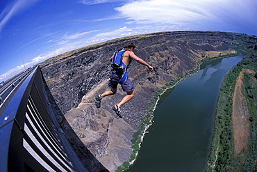 A BASE jumper jumps off a bridge in Twin Falls, Idaho (Wide Angle Lens).