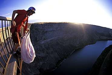 A BASE jumper holds his parachute as he gets ready to jump off of a bridge in Twin Falls, Idaho (Wide Angle Lens).