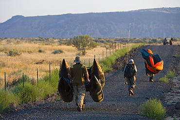 Flyfishermen with their gear walk to a hidden desert lake in eastern Washington.