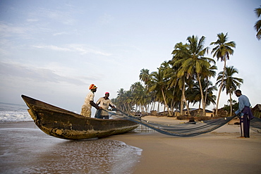 Fishermen pulling nets on a beach in Ghana