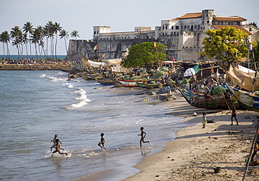 Children running into the sea in Elmina