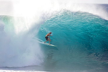 man surfing on a large wave at Pipeline, Hawaii