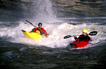 A father and daughter enjoy an afternoon kayaking in the rapids.