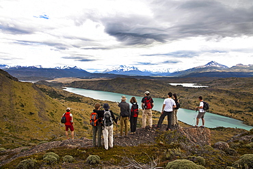 TORRES DEL PAINE NATIONAL PARK, PATAGONIA, CHILE. Hikers enjoy one of the best national parks in South America on a sunny day. With steep peaks full of hanging glaciers and glacial silt-filled lakes, Torres del Paine is one of the greatest attractions on Earth.