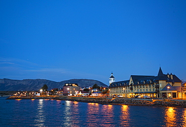 PUERTO NATALES, PATAGONIA, CHILE. A waterfront town is lit up at night.