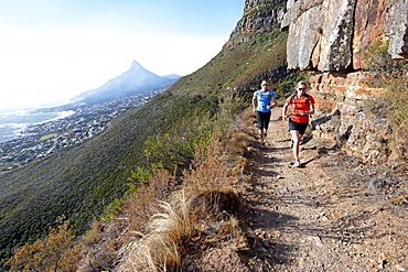 Katrin Schneider and Susann Scheller running on the Pipe Track above Camps Bay and below the Twelve Apostles. Cape Town, South Africa.