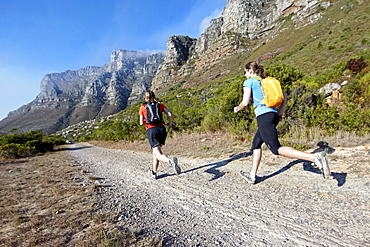 Katrin Schneider and Susann Scheller running on the Pipe Track above Camps Bay and below the Twelve Apostles. Cape Town, South Africa.