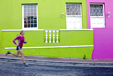 Katrin Schneider running trough the streets of the very colorful Bo-Kaap or Capa Malay Quarter of Cape Town. South Africa.