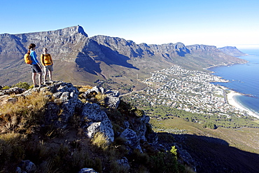 Katrin Schneider and Susann Scheller standing on top of Lion's Head looking down at Camps Bay and the city of Cape Town. South Africa.