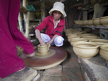 Workers making ceramics with foot powered wheel in Hoi An, Vietnam