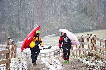 Two kayakers transport their kayaks in Tennessee.