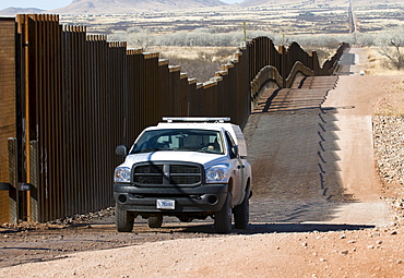 A US border patrol drives the new pedestrian fence on Mexican border, AZ.