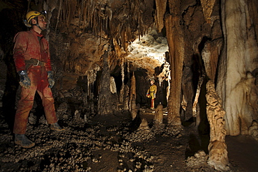 Cave explorers pose infront of cave formations underground in China.