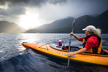 Middle aged woman kayaking on Lake Crescent, Olympic National Park, WA, USA