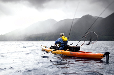 Young male fishing from a kayak on Lake Crescent Olympic National Park, Washington, USA