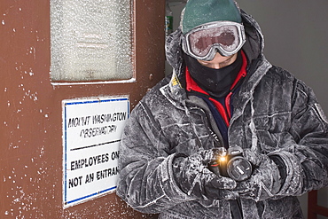 A person examines his camera after being exposed to  the severe elements of wind and temperature on Mt. Washington's summit in w