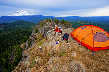 Two young women enjoy the view while camping along Sleeping Beauty in the Pacific Northwest