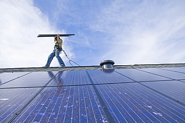 A worker installs solar panels on a rooftop in Redmond, WA.