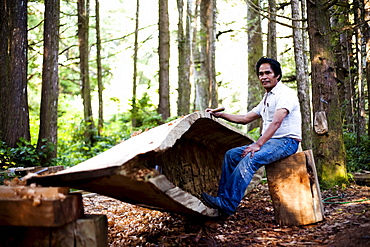 A man native to the West Coast of Vancouver Island carves a canoe as his tribes have for centuries.