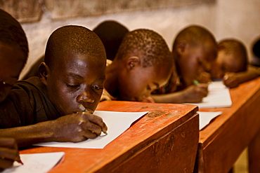 Boys work at their desks in a Rwandan school house.