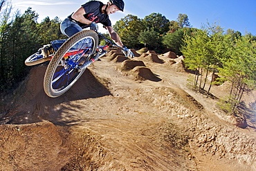 A man flying through the air on a mountain bike.