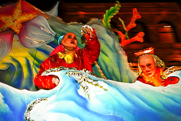 Mardi Gras float with crew members throwing beads to parade spectators in New Orleans.