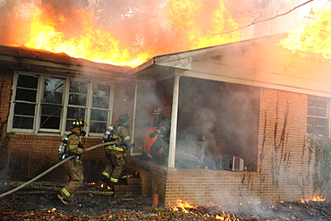 Firefighters extinguishing house fire