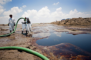 Press tour with Louisiana Governor Bobby Jindal. Clean-up crews sucking oil with vacuum tubes and placing absorbant pompom booms.   East Grand Terre was involved in a Barrier Island restoration project before the oil spill.