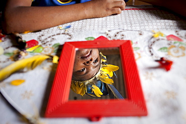 An Oro Win girl wears a head dress as she prepares for a traditional