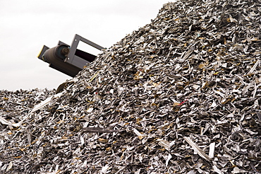 Workers at Atlas Metal & Iron weigh scrap metal for sale on a scale in their vast Denver yard.