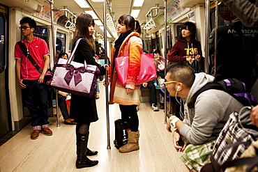 Fashionable teenage girls ride the MRT in Taipei, Taiwan, October 29, 2010.