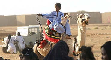 A Toureg child rides atop his camel, Gao, Mali, West Africa