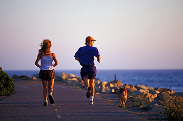 Lynne Siodmak, Brian Crowder  and Evie run on the Ojai Valley Trail along the ocean in Ojai, California.