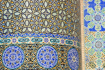 Floral & geometric patterns of  restored Timurid tile mosaics decorate a wall in the courtyard of the Friday Mosque or "Masjid-i Jami", the largest mosque in Herat, dating to 1200 AD, Herat, Afghanistan.  Much of the Ghorid and Timurid decorations on the mosque had been badly damaged during the centuries, but a restoration project begun in 1943 continues today.