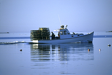 A lobster boat moves its traps in Muscungus Bay, Maine.