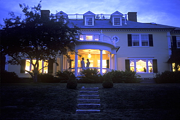 A couple takes in the evening air at Dark Harbor House on Isleboro, Maine.