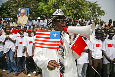 Liberians line the streets of Monrovia, Liberia to celebrate Chinese President Hu's visit. Besides rebuilding the National football stadium Chinese aid to the war torn nations is very popular with the locals. Liberia is rich in iron ore, timber, rubber and other resources which are desired by China.