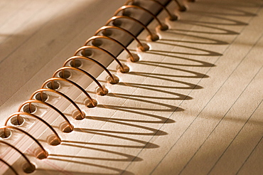 Morning light casting a shadow on a notebook.