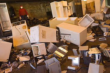 At CRT Recycling in Brockton, Massachusetts a worker recycles old refrigerators for electronic components and copper.