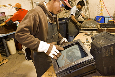 Workers at ElectroniCycle, a recycling company in Gardner, Massachusetts take apart old televisions for recycling.